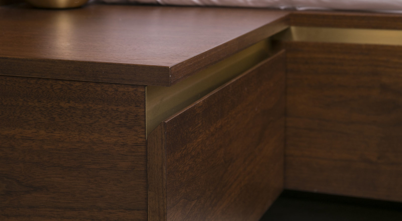handless walnut bedside table with satin brass detail
